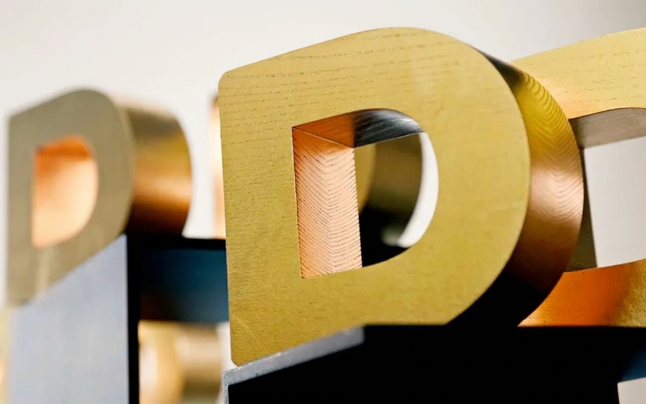 Trofeo Danish Design Award in frassino con finitura dorata, visto in prospettiva di tre quarti